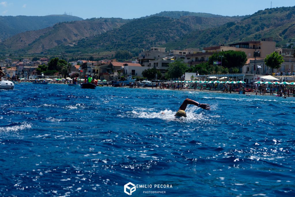 Nuotatore durante la Traversata dello Stretto, sullo sfondo la costa di Villa San Giovanni